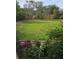 Spacious back yard with grass, trees and a wooden fence providing privacy at 6197 Belkton Ave, Spring Hill, FL 34608