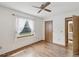 Light-filled bedroom features wood floors, a ceiling fan, and a view to the backyard at 6197 Belkton Ave, Spring Hill, FL 34608