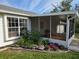 Charming home exterior featuring a screened lanai and a well-maintained flower bed at 6197 Belkton Ave, Spring Hill, FL 34608