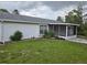Home exterior shows the screened lanai and landscaping on a cloudy day at 6197 Belkton Ave, Spring Hill, FL 34608
