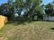 Fenced backyard featuring a grassy yard and mature trees that provide privacy for outdoor enjoyment at 6406 Stone Rd, Port Richey, FL 34668