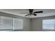 Cozy bedroom with neutral walls, ceiling fan, and two windows at 6406 Stone Rd, Port Richey, FL 34668