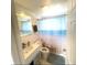 Bright bathroom with a vanity sink and bathtub with an ocean-themed shower curtain at 6603 Adams St, New Port Richey, FL 34652