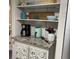 Kitchen displaying open shelving, a coffee maker, granite countertop, and decorative storage at 6603 Adams St, New Port Richey, FL 34652