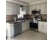 Updated kitchen with stainless steel appliances and white cabinets, seamlessly combining style and functionality at 6603 Adams St, New Port Richey, FL 34652