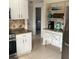 Bright eat-in kitchen with white cabinets, open shelving, and stainless steel appliances creating a cozy atmosphere at 6603 Adams St, New Port Richey, FL 34652
