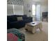 Comfortable living room with a large sofa, neutral tile flooring, and natural light at 6603 Adams St, New Port Richey, FL 34652