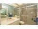 Well-lit bathroom featuring a toilet, sink, and glass-enclosed shower at 6620 Brambleleaf Dr, Spring Hill, FL 34606