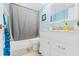 Bathroom featuring tiled shower behind curtain, white vanity, and toilet at 6656 Pinecrest N Ln, Pinellas Park, FL 33781