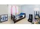 Well-lit bedroom featuring blue accent wall and gaming chair at 6656 Pinecrest N Ln, Pinellas Park, FL 33781