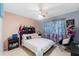 Bedroom with grey and pink walls, fan, large bed and seating at 6656 Pinecrest N Ln, Pinellas Park, FL 33781