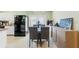 Modern dining area with kitchen view, stylish chairs, and a chic buffet at 6656 Pinecrest N Ln, Pinellas Park, FL 33781