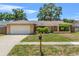 Charming single-story home with a well-manicured lawn and a two-car garage in a suburban neighborhood at 6656 Pinecrest N Ln, Pinellas Park, FL 33781