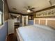 Bright bedroom features a comfortable queen-sized bed, mirrors, and a walk-in door to the bathroom at 7104 Fair Ln, Hudson, FL 34667