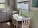 Cozy dining area with a white table and chairs, with a window view and light green walls at 7104 Fair Ln, Hudson, FL 34667