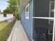 Side exterior view of the home showing the brick paver walkway and screened-in porch area at 7104 Fair Ln, Hudson, FL 34667