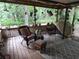 Cozy screened-in back porch with rocking chair, rugs, plants, and vintage decorations at 7323 Ray Browning Rd, Brooksville, FL 34601