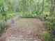 A fenced backyard offers a contained outdoor area with plants, leaves, and a brick paver patio at 7323 Ray Browning Rd, Brooksville, FL 34601