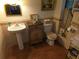 A cozy bathroom boasts a pedestal sink, decorative cabinet, and a tiled floor, adding character to the space at 7323 Ray Browning Rd, Brooksville, FL 34601