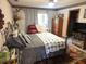 Cozy bedroom featuring a metal bed frame with grey comforter, a TV, and floral wallpaper at 7323 Ray Browning Rd, Brooksville, FL 34601