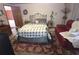 Comfortable bedroom with ornate metal bed frame, neutral bedding, and plush red area rug at 7323 Ray Browning Rd, Brooksville, FL 34601