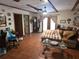 Tile-floored living room with exposed beams, a leather sofa, and a decorative coffee table at 7323 Ray Browning Rd, Brooksville, FL 34601