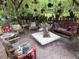 Outdoor seating area under a pergola, stone table, potted plants, and many decorations at 7323 Ray Browning Rd, Brooksville, FL 34601