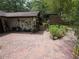 Charming brick patio with lush greenery and an eclectic array of decorative wall hangings and potted plants at 7323 Ray Browning Rd, Brooksville, FL 34601