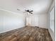 Spacious bedroom featuring wood-look flooring, ceiling fan, and natural light from the window at 7353 Thorpp Ave, Brooksville, FL 34613