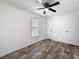 Comfortable bedroom featuring wood-look flooring, ceiling fan, and natural light from the window at 7353 Thorpp Ave, Brooksville, FL 34613
