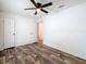 Bedroom with wood-look flooring, ceiling fan, two closets, and doorway to another room at 7353 Thorpp Ave, Brooksville, FL 34613