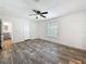 Bright bedroom with stylish wood-look flooring, ceiling fan, and open doorway to the ensuite at 7353 Thorpp Ave, Brooksville, FL 34613