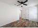 Bedroom with wood-look flooring, ceiling fan, two closets, and doorway to another room at 7353 Thorpp Ave, Brooksville, FL 34613