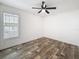 Bright bedroom featuring wood-look flooring, ceiling fan, and natural light from the window at 7353 Thorpp Ave, Brooksville, FL 34613