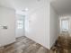 Bright entryway featuring wood-look floors and white walls, leading to a hallway and a front door at 7353 Thorpp Ave, Brooksville, FL 34613