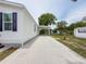 Side view of a single-story home with a long, concrete driveway and carport at 7353 Thorpp Ave, Brooksville, FL 34613