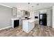 A modern kitchen with gray cabinetry, an island, stainless steel appliances, and wood-look flooring at 7353 Thorpp Ave, Brooksville, FL 34613