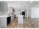 A modern kitchen with gray cabinets, an island, stainless steel appliances, and wood-look flooring at 7353 Thorpp Ave, Brooksville, FL 34613