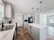 Close-up of kitchen island and countertops, cabinets, appliances, and wood-look flooring at 7353 Thorpp Ave, Brooksville, FL 34613