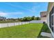 Spacious backyard featuring a well-maintained lawn, white fence, and lush greenery for outdoor enjoyment at 7523 Tangle Brook Blvd, Gibsonton, FL 33534