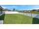 Large, green backyard enclosed by a white fence, providing a private and secure outdoor space at 7523 Tangle Brook Blvd, Gibsonton, FL 33534