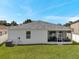Large backyard showcasing a well-maintained lawn, a screened-in patio, and ample space for outdoor activities at 7523 Tangle Brook Blvd, Gibsonton, FL 33534
