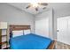 Comfortable bedroom features a ceiling fan, wood-look flooring, and a blue quilted bedspread at 7523 Tangle Brook Blvd, Gibsonton, FL 33534
