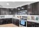 Modern kitchen featuring dark cabinetry, stainless steel appliances, a kitchen island, and recessed lighting at 7523 Tangle Brook Blvd, Gibsonton, FL 33534