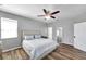 Bright main bedroom with wood-look floors, a ceiling fan, and ample closet space at 7523 Tangle Brook Blvd, Gibsonton, FL 33534