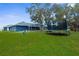 Spacious backyard with a well-maintained lawn, trampoline, and screened-in patio, ideal for relaxing and entertaining at 8084 Nightingale Rd, Weeki Wachee, FL 34613