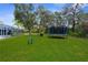 Expansive backyard featuring a trampoline, lush lawn, and a playset, perfect for outdoor activities and Gathering fun at 8084 Nightingale Rd, Weeki Wachee, FL 34613