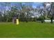Large backyard with a wooden playset, slide, swing set and trampoline, offering plenty of space for children to play at 8084 Nightingale Rd, Weeki Wachee, FL 34613