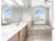 Bright bathroom featuring a double vanity, bathtub, and arched windows offering natural light at 8084 Nightingale Rd, Weeki Wachee, FL 34613