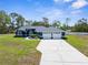 Beautiful single-story home with a well-manicured lawn, arched entryway, and attached three-car garage at 8084 Nightingale Rd, Weeki Wachee, FL 34613